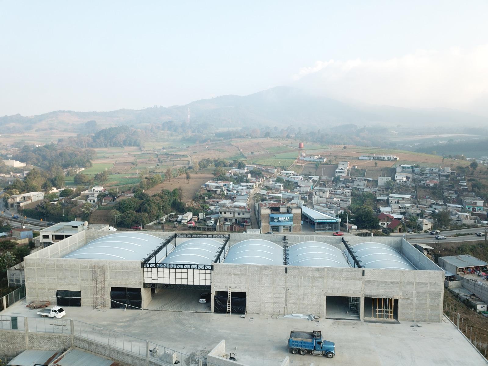 Vista general de cinco bodegas con techos curvos en Patzicía